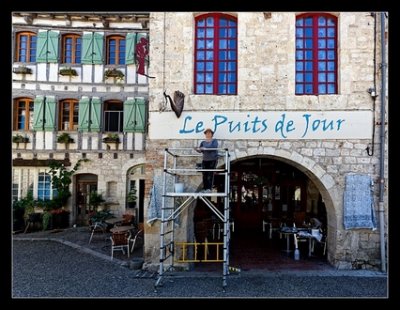 A l&rsquo;occasion de ses 25 ans, "Le Puits de Jour", café musical, fait peau neuve avec son enseigne refaite par Claudine Quersin, peintre historique de cette façade emblématique de Lauzerte...